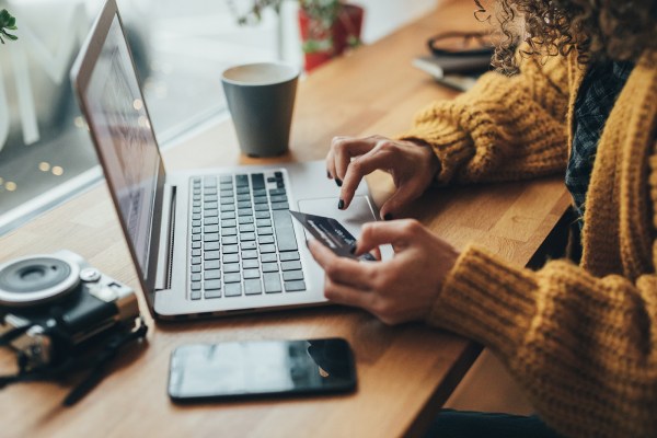 Woman in cafe shopping online with laptop. Photo by filadendron/Getty Images